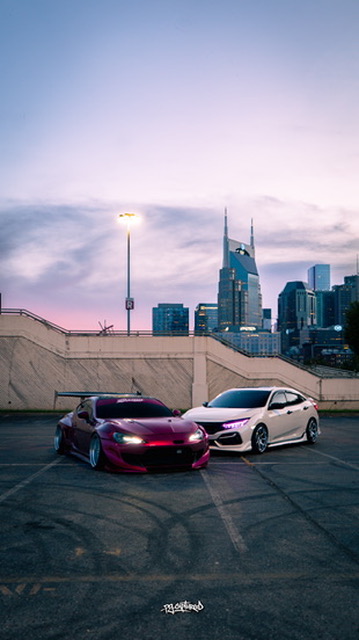 Two modified cars with the Nashville skyline