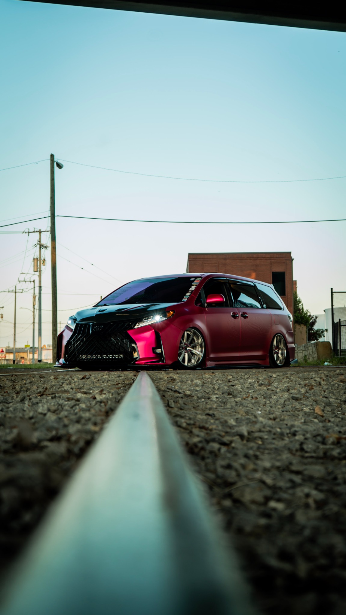 Modified pink minivan photographed from a low angle